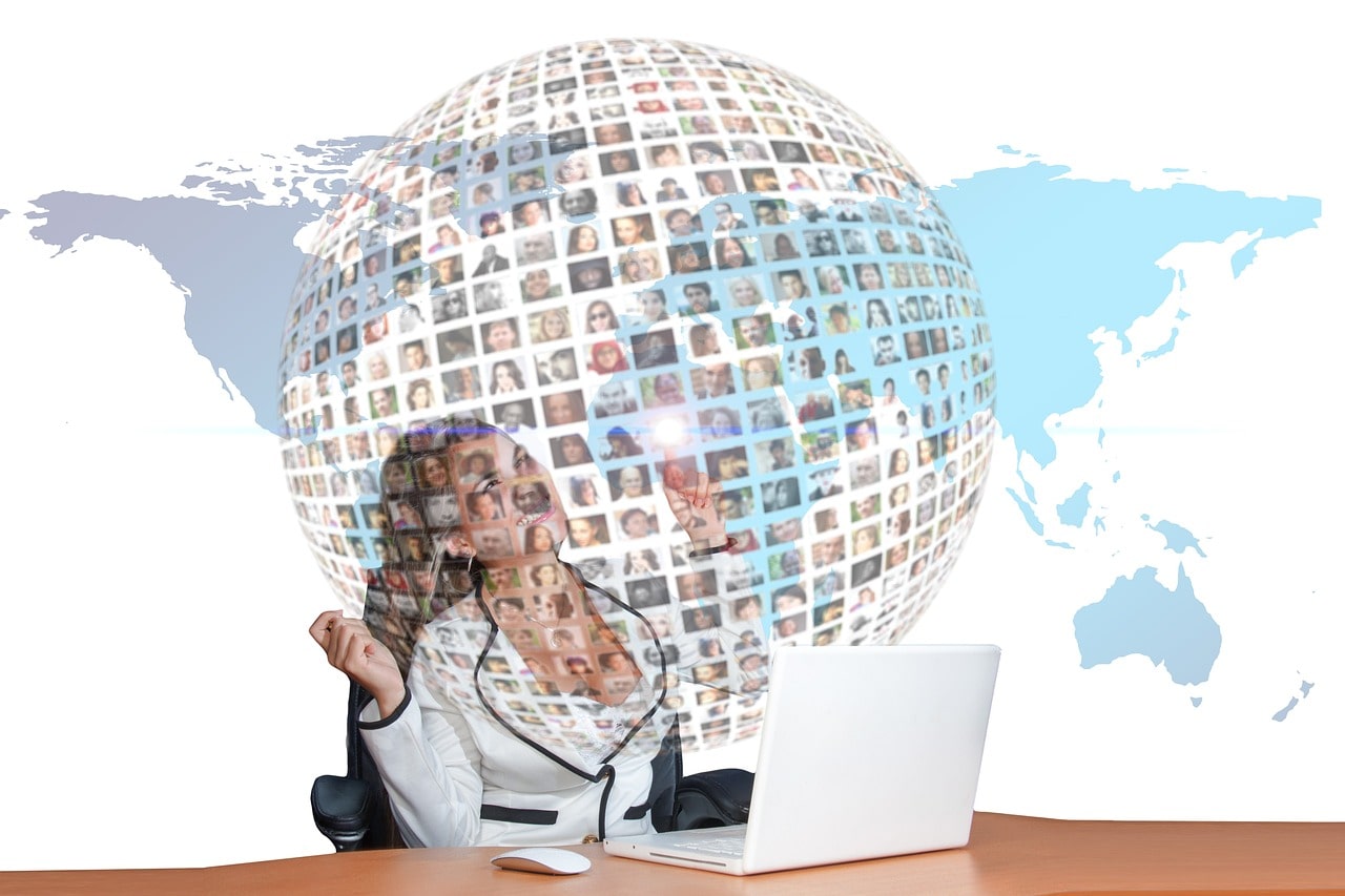 Starting a Podcast Woman Sitting at Desk with Laptop with Globe Overlay
